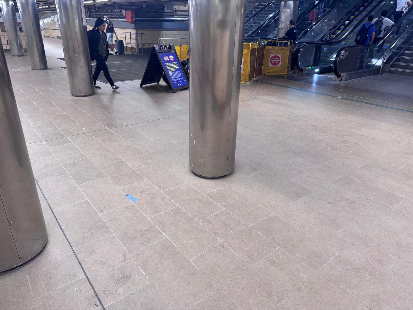Newport PATH Station floor tile near columns and escalators